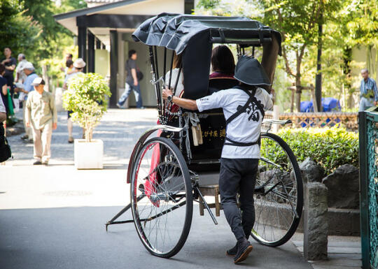 A man pulling people in a cart