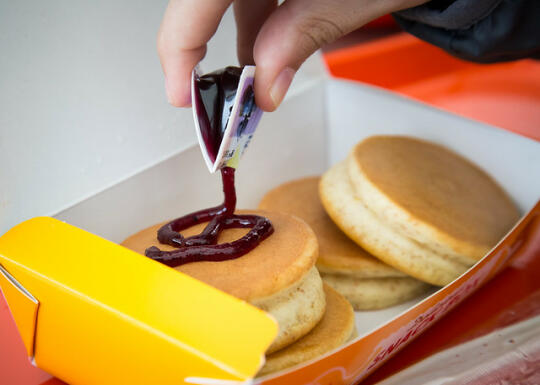 Squeezing blueberry jam on the pancakes