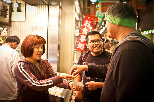 Brian and Francis buying something at Nishiki Market