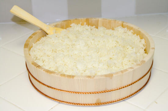 Sushi rice in a wooden hangiri (a large, flat, round container)