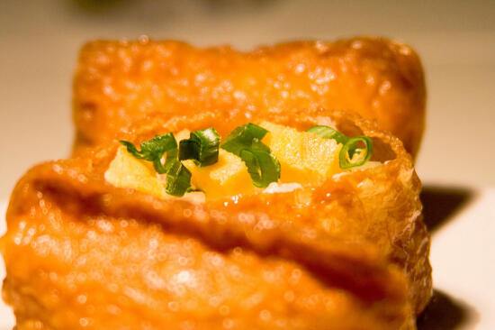 Inari-zushi, topped with tamago and green onion