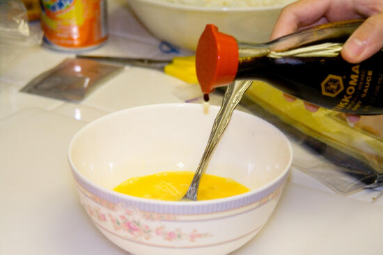 Pouring shoyu into the egg