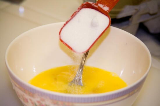 Pouring sugar into the egg