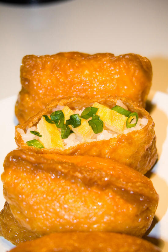 Inari-zushi, topped with tamago and green onion